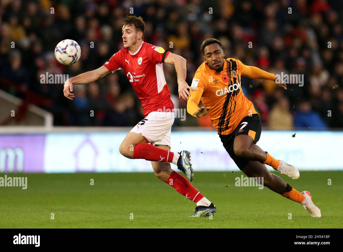 Liam Kitching di Barnsley (a sinistra) e Mallik Wilks di Hull City combattono per la palla durante la partita del Campionato Sky Bet a Oakwell, Barnsley. Data foto: Sabato 6 novembre 2021. Foto Stock