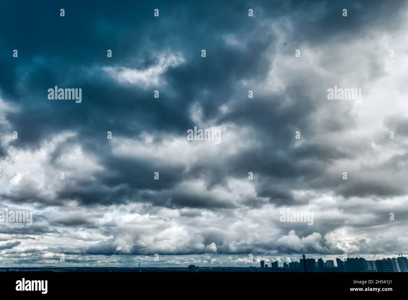 Cumulonimbus nuvole su silhouette di edifici a più piani Foto Stock