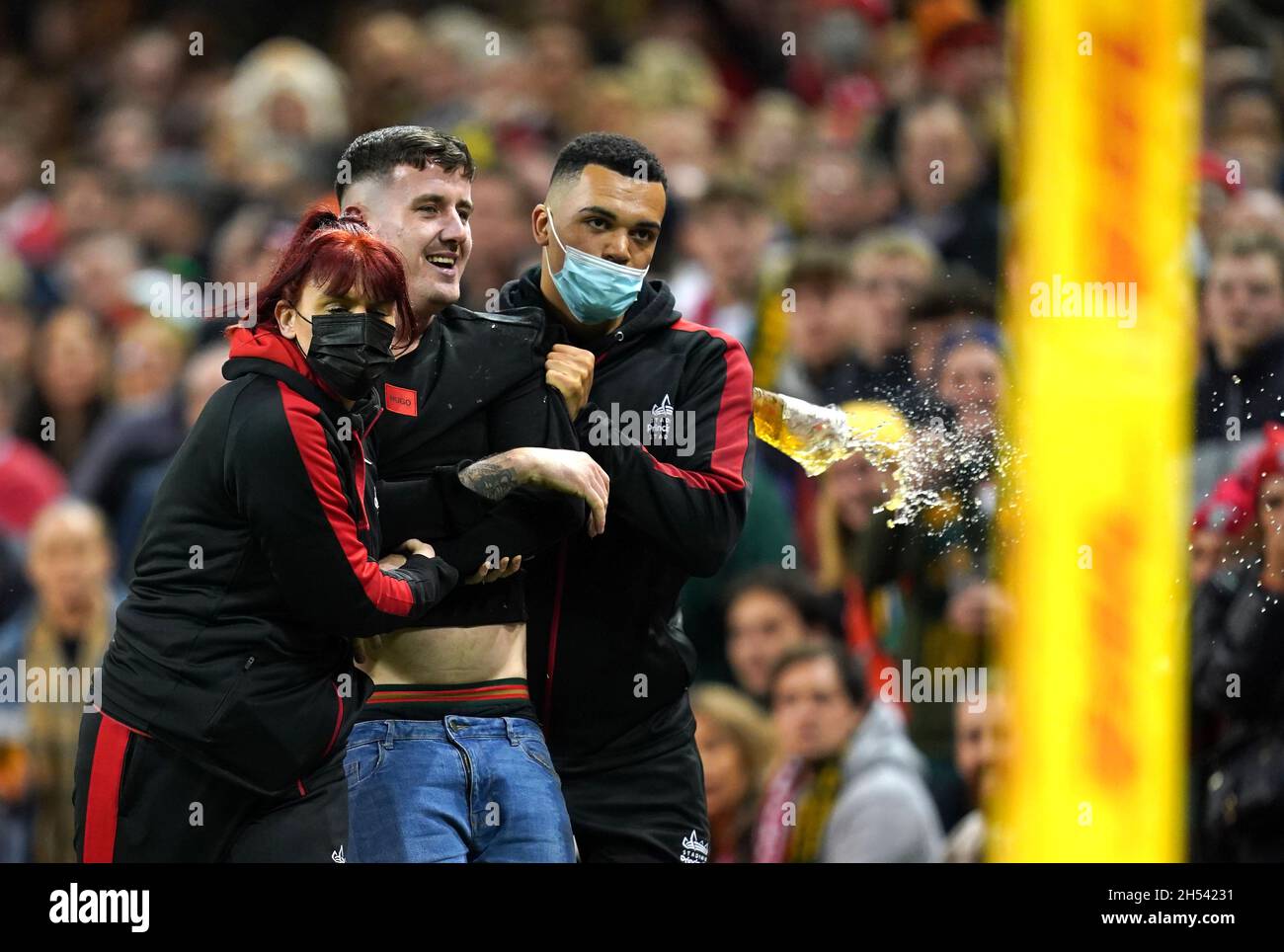 Gli steward rimuovono un fan che invade il campo durante la partita Autumn Internationals al Principality Stadium di Cardiff. Data foto: Sabato 6 novembre 2021. Vedi la storia della Pennsylvania RUGBYU Wales. Il credito fotografico deve essere: David Davies/PA Wire. RESTRIZIONI: L'uso è soggetto a restrizioni. Solo per uso editoriale, nessun uso commerciale senza previo consenso da parte del titolare dei diritti. Foto Stock