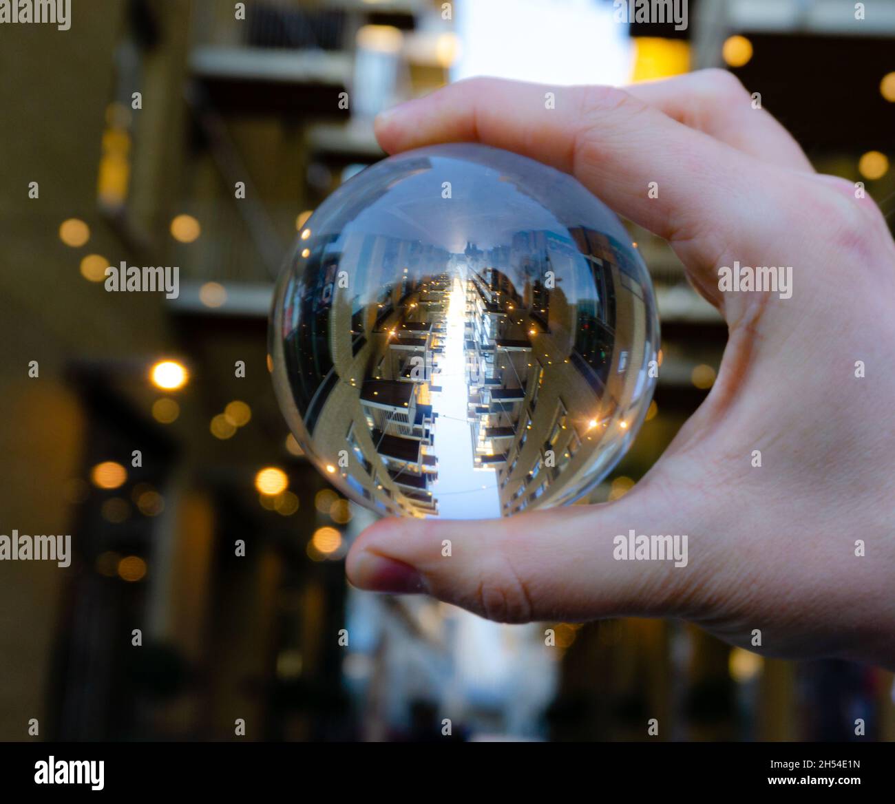 palla obiettivo in mano con sfondo edificio Foto Stock