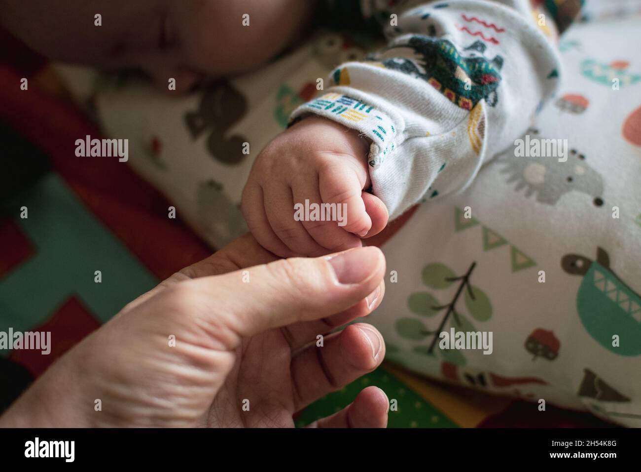 Primo piano su una mano del neonato che tiene il dito della madre. Foto Stock