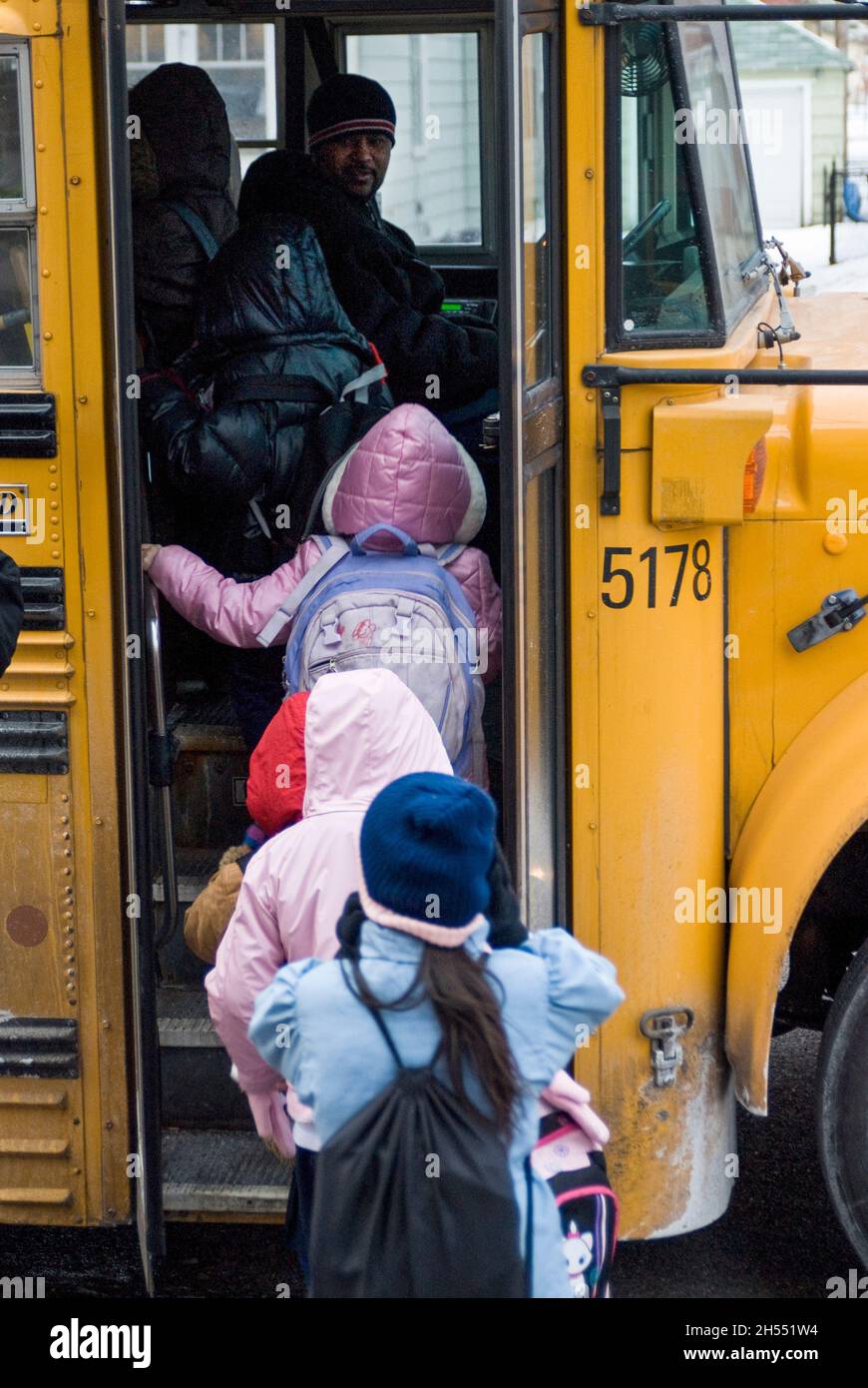 St. Paul, Minnesota. Scuola charter per l'Hmong. Gli studenti di Hmong lasciano la scuola in una giornata fredda per salire sul bus della scuola. Foto Stock