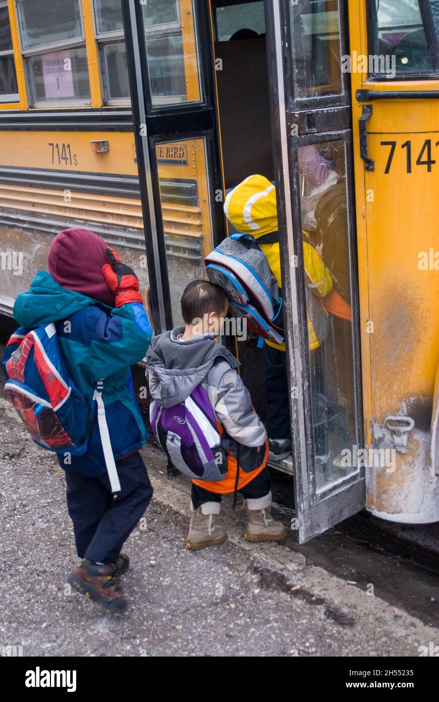 St. Paul, Minnesota. Scuola charter per l'Hmong. Gli studenti di Hmong lasciano la scuola in una giornata fredda per salire sul bus della scuola. Foto Stock