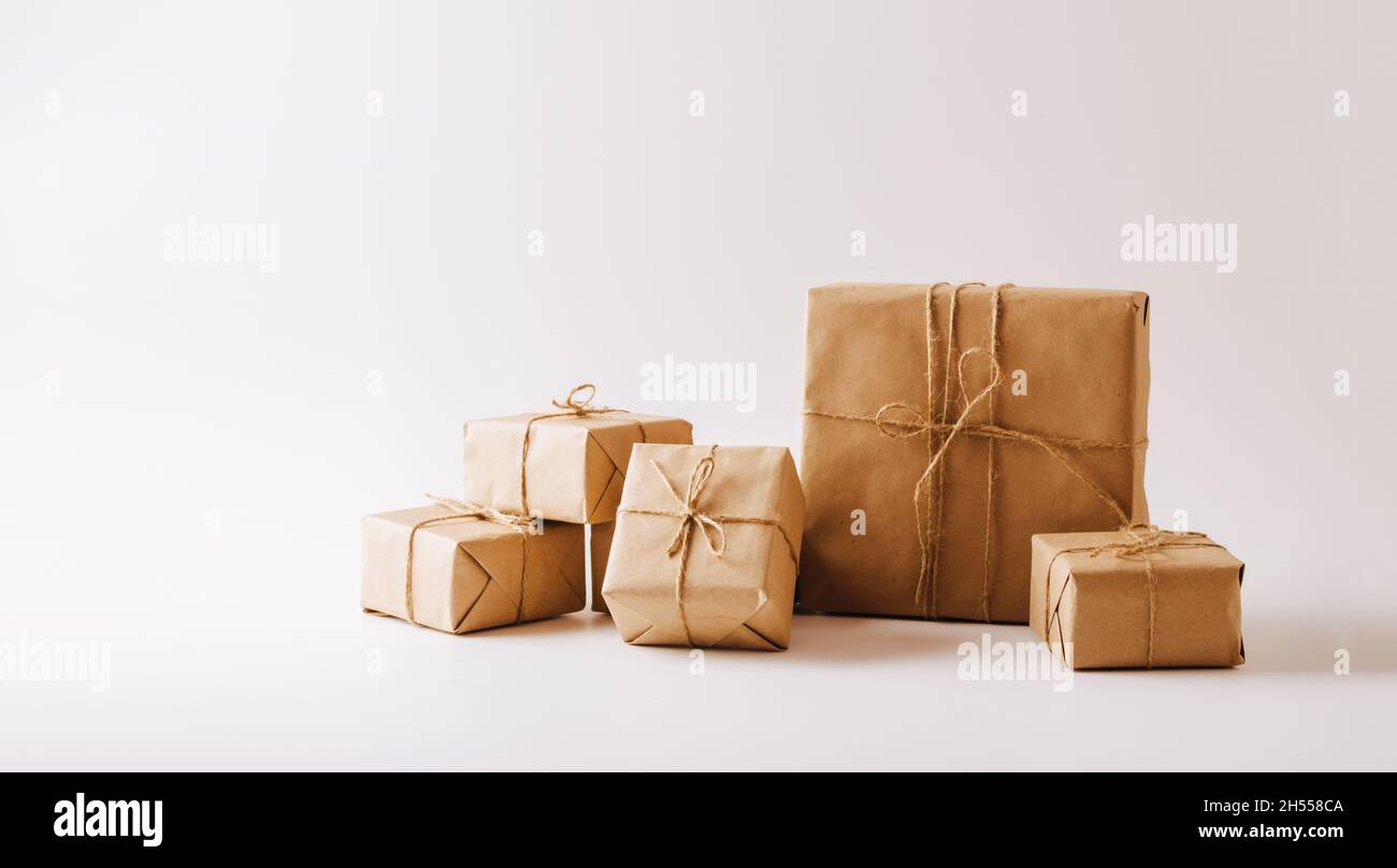 Regali in confezioni cartacee ecocompatibili su sfondo bianco. Copiare il concetto di spazio minimalismo Foto Stock