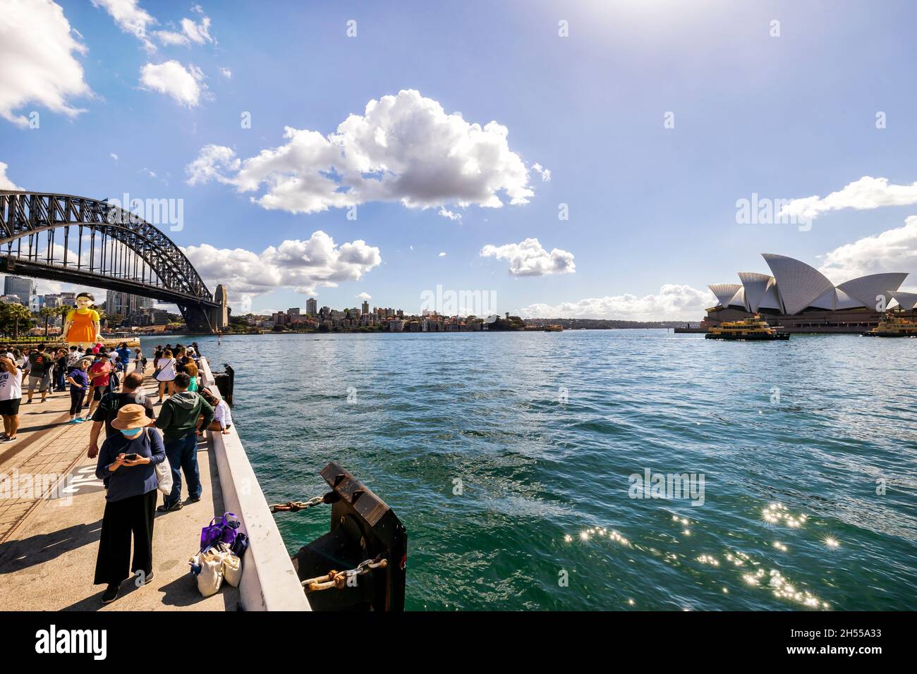 Sydney, Australia – 31 Ott 2021: Bambola di gioco di calamari vicino a Harbour Bridge e all'Opera House con una folla di fan. Foto Stock