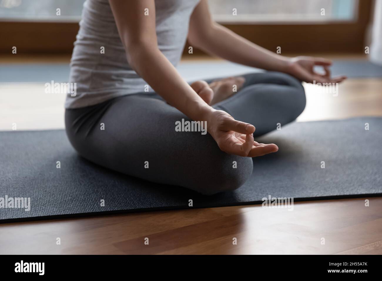 Primo piano ritagliato immagine donna meditating seduta cross-zampe indoor Foto Stock