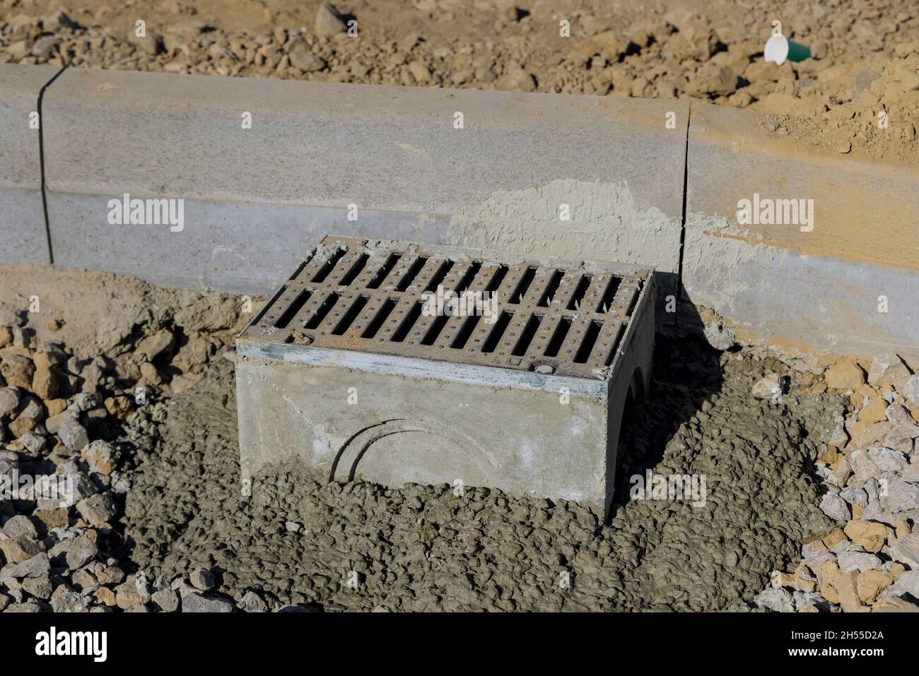 Nuovi pozzi fognari in cemento posa di fognature durante la costruzione di strade Foto Stock