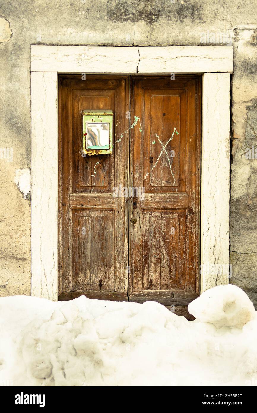 Vecchia porta di legno mezzo coperto di neve Foto Stock