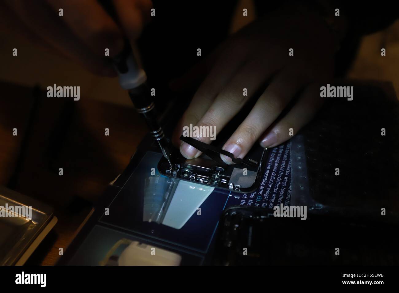 Tecnico che ripara lo smartphone danneggiato, modifica di uno schermo Foto Stock