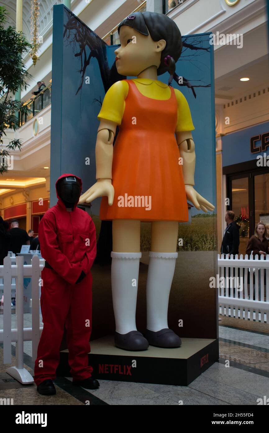 Squid Game, bambola a luce rossa verde nel centro commerciale Trafford Center con guardia. Manchester Regno Unito Foto Stock