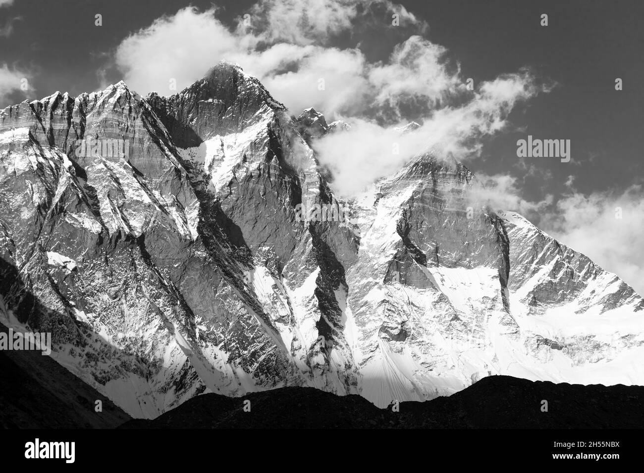 Monte Lhotse con le nuvole sulla cima - modo per il campo base Everest, valle di Khumbu, parco nazionale Sagarmatha, montagne nepalesi Himalaya, nero e. Foto Stock