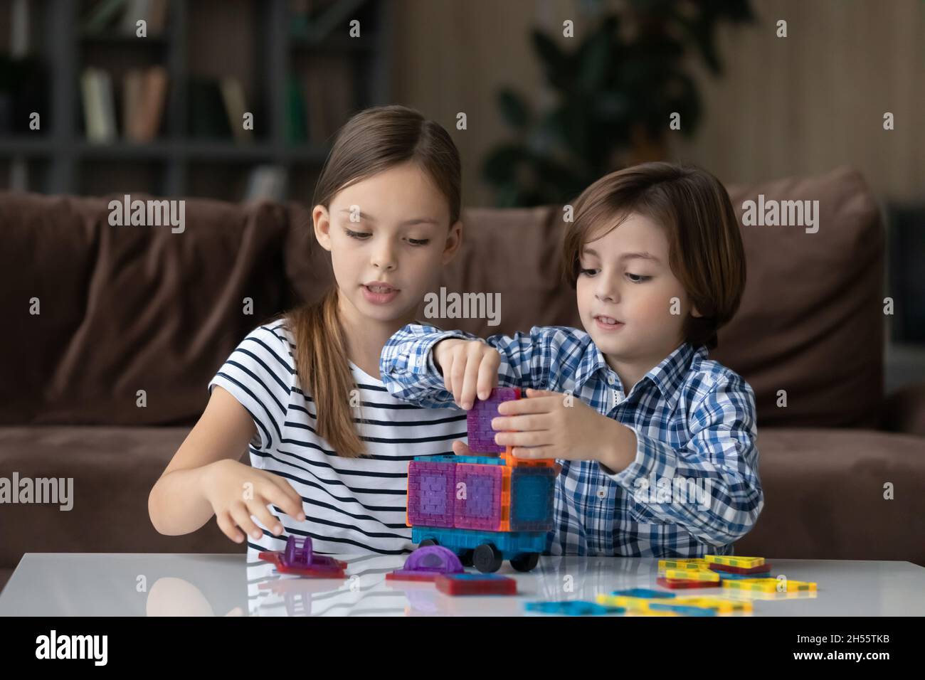 Ragazzino e ragazza che giocano con blocchi di plastica colorati Foto Stock