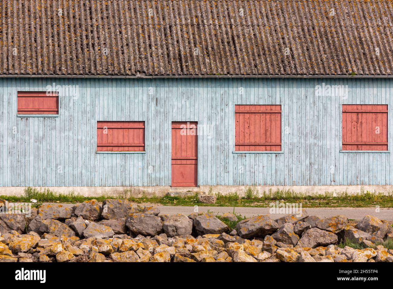 Casa in legno dipinta di blu chiaro, porte rosse e persiane. Cayeux-sur-Mer, Costa d'Opale, Francia Foto Stock