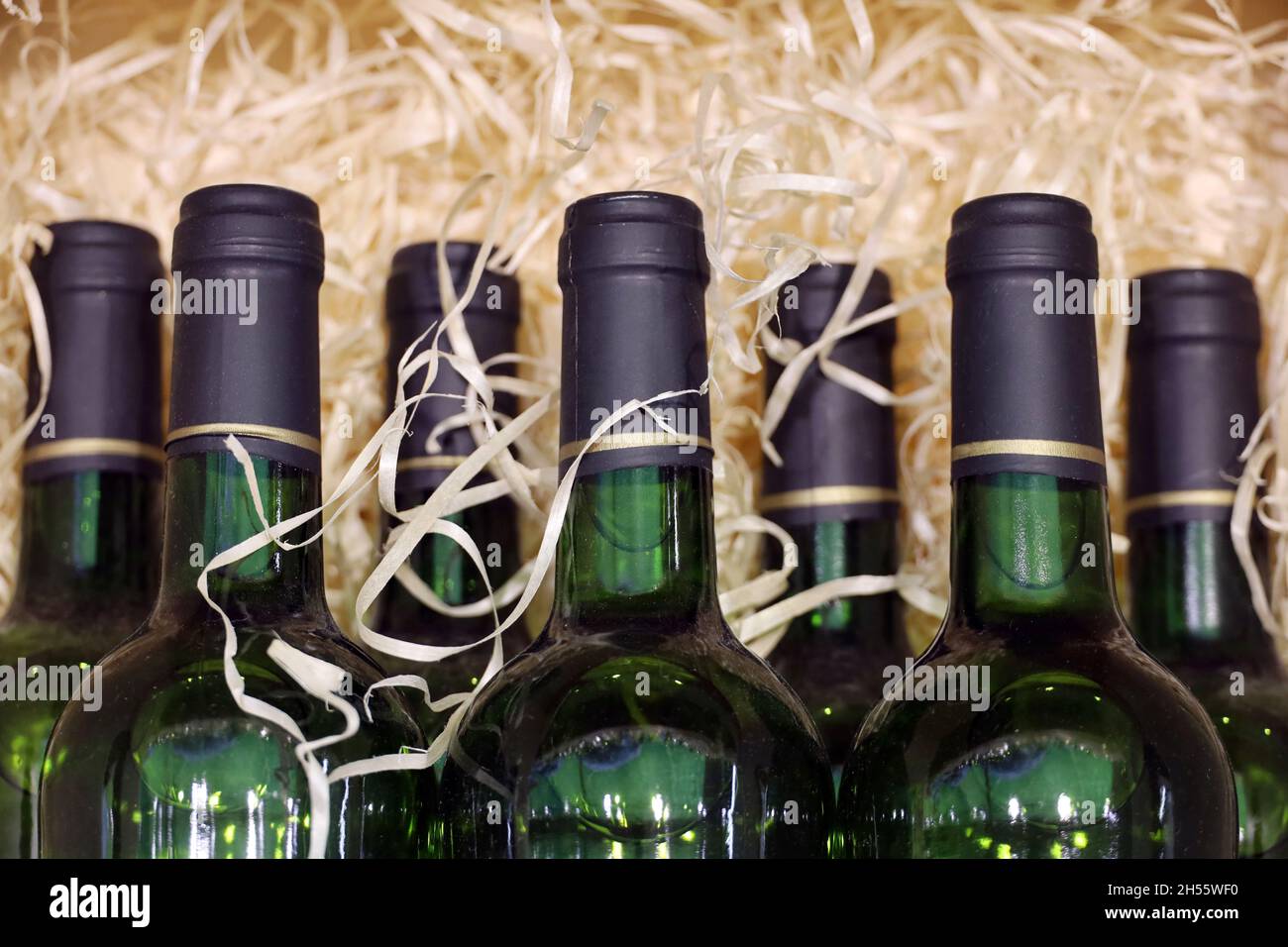 Bottiglie di vino in trucioli di legno. Negozio di liquori, vino bianco in scatola per il trasporto Foto Stock