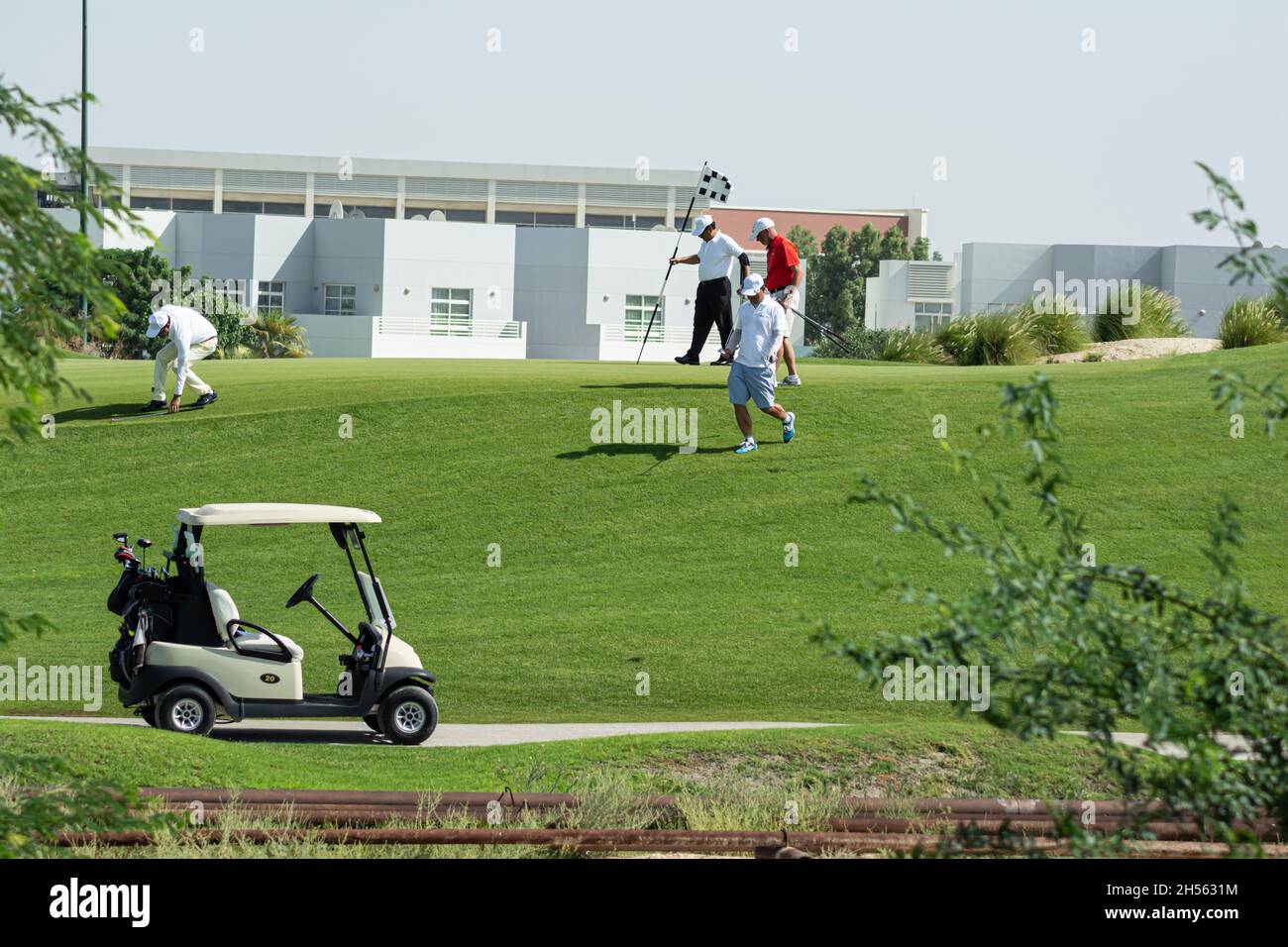 persone che giocano a golf e golf cart Foto Stock