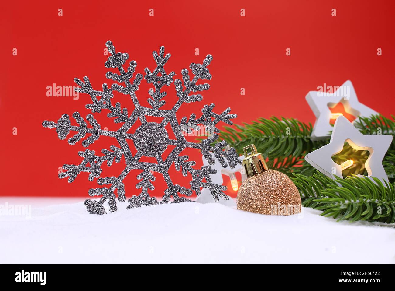Fiocco di neve frizzante in argento con lanterne stellari e rami di abete verde e palle lucide su sfondo rosso. Natale, Capodanno. Spazio di copia Foto Stock Fiocco di neve frizzante in argento con lanterne stellari e rami di abete verde e palle lucide su sfondo rosso. Natale, Capodanno. Spazio di copia Foto Stock
