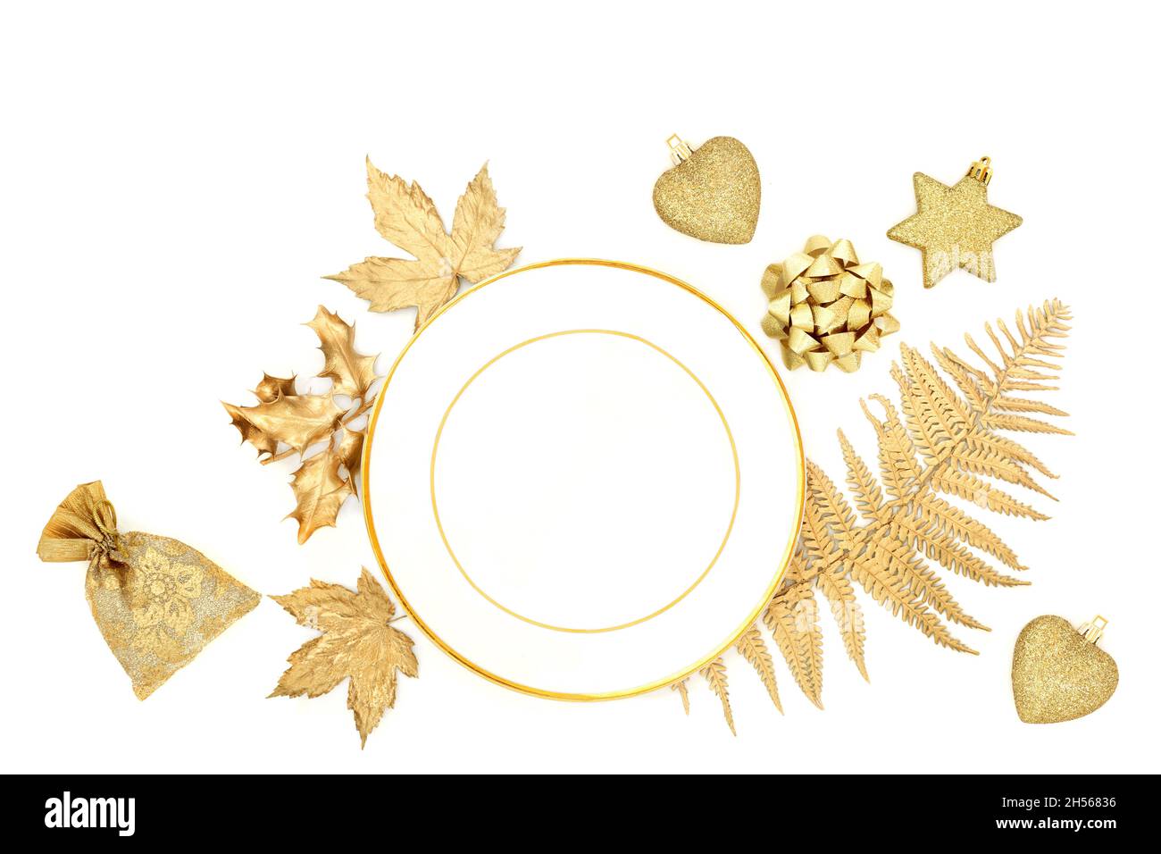 Natale decorativo bianco e oro tavolo impostazione con piatto di porcellana, foglie, albero decorazione bauble, articoli da regalo. Design festivo per Natale. Foto Stock