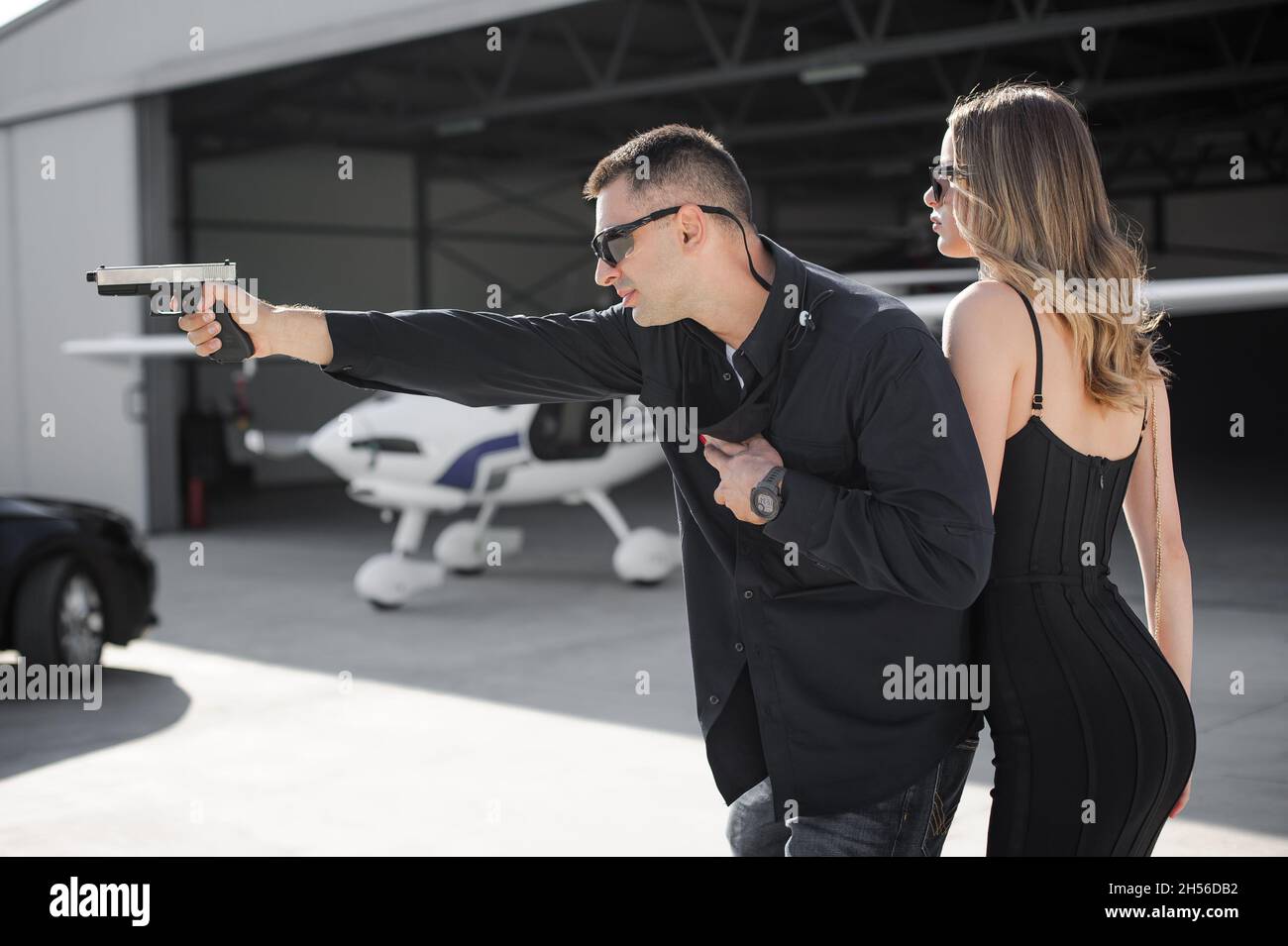 Guardia del corpo celebrità e VIP persona di sicurezza vicino servizi di protezione. Agente di polizia professionale forze speciali con occhiali da sole in tuta civile nera Foto Stock