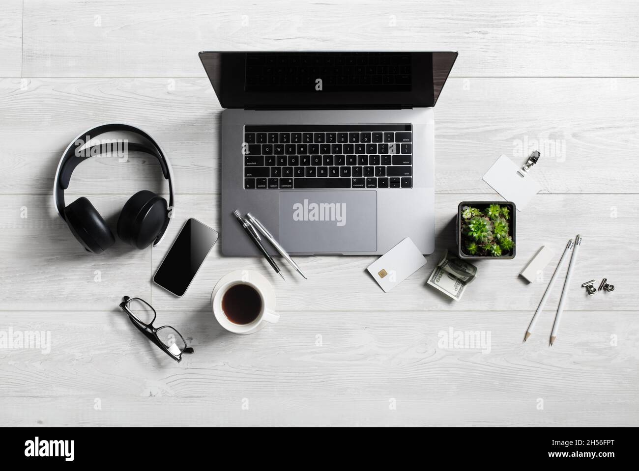 Area di lavoro per ufficio con forniture e gadget su sfondo in legno. Disposizione piatta. Foto Stock