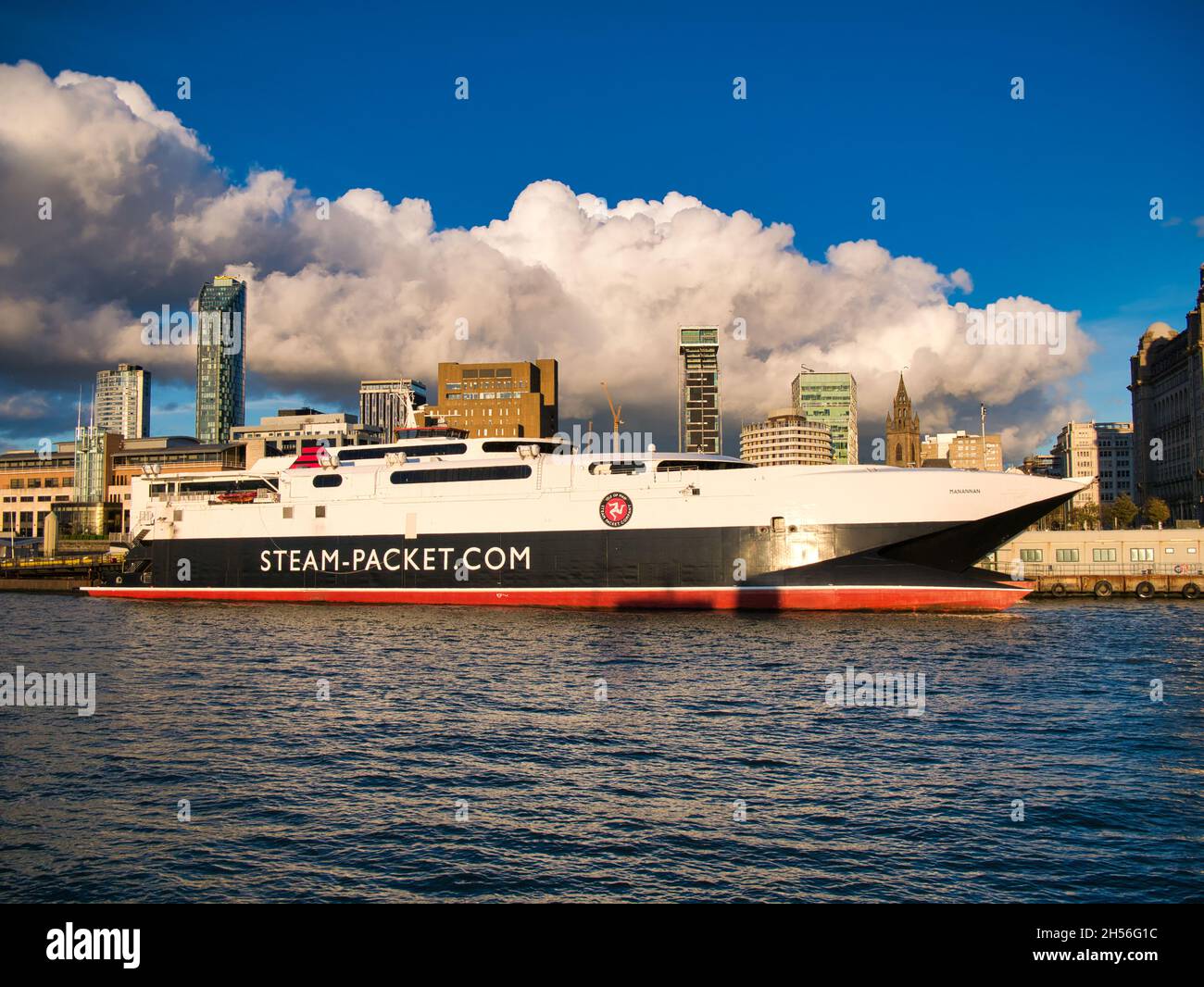 L'isola di Man traghetto HSC Manannan ormeggiato a Liverpool in una giornata di sole con moderni uffici e palazzi di appartamenti dietro. Il traghetto è stato costruito da Incat Foto Stock