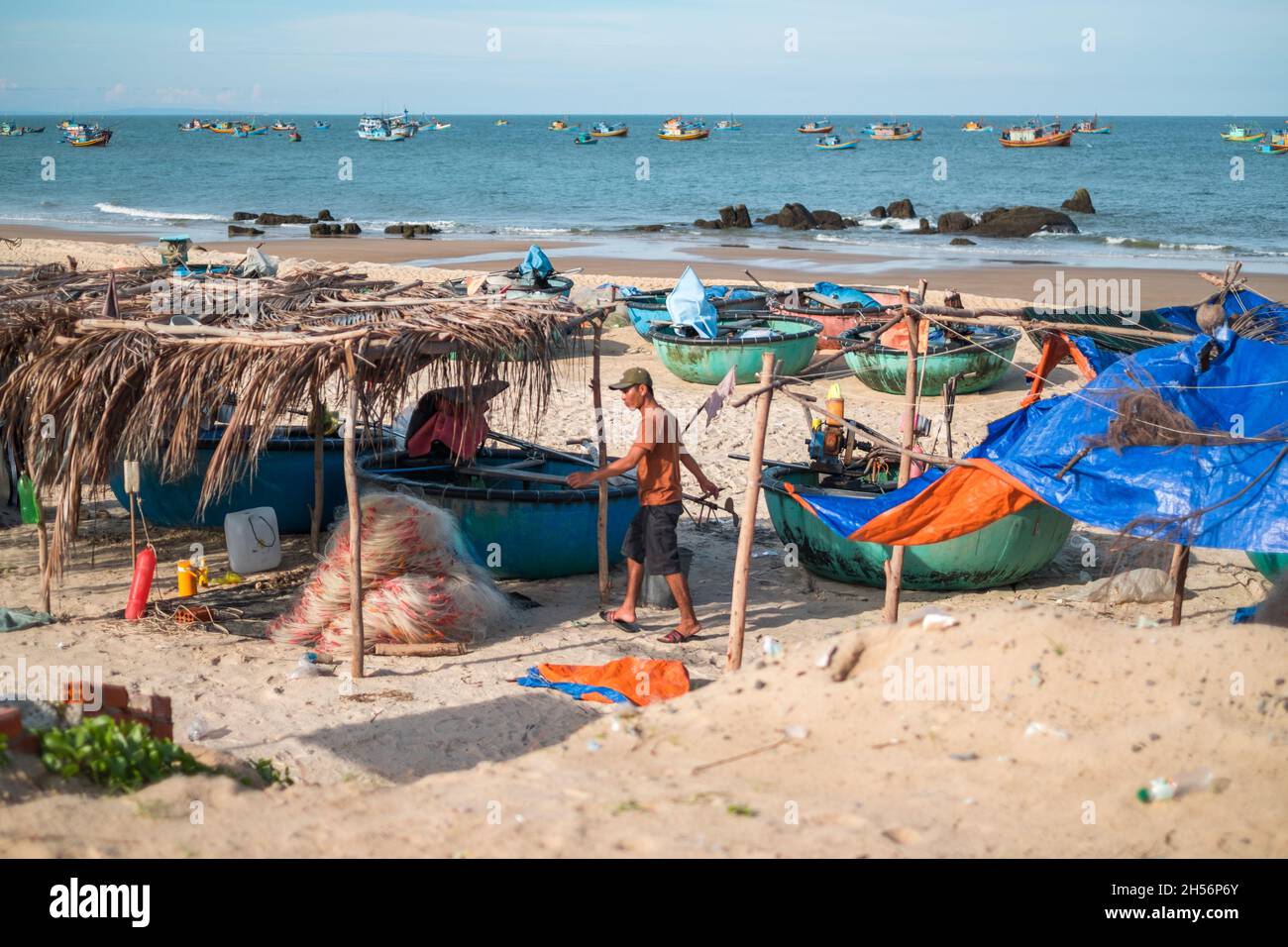 Vista panoramica della spiaggia con colorate barche da pesca e casereccio povero baldacchino pesca sul mare. Giro barche da pesca sulla spiaggia. Pescatore locale Foto Stock