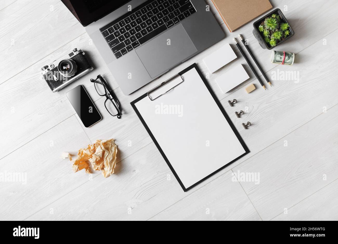 Cancelleria e gadget in bianco su sfondo di legno. Disposizione piatta. Foto Stock