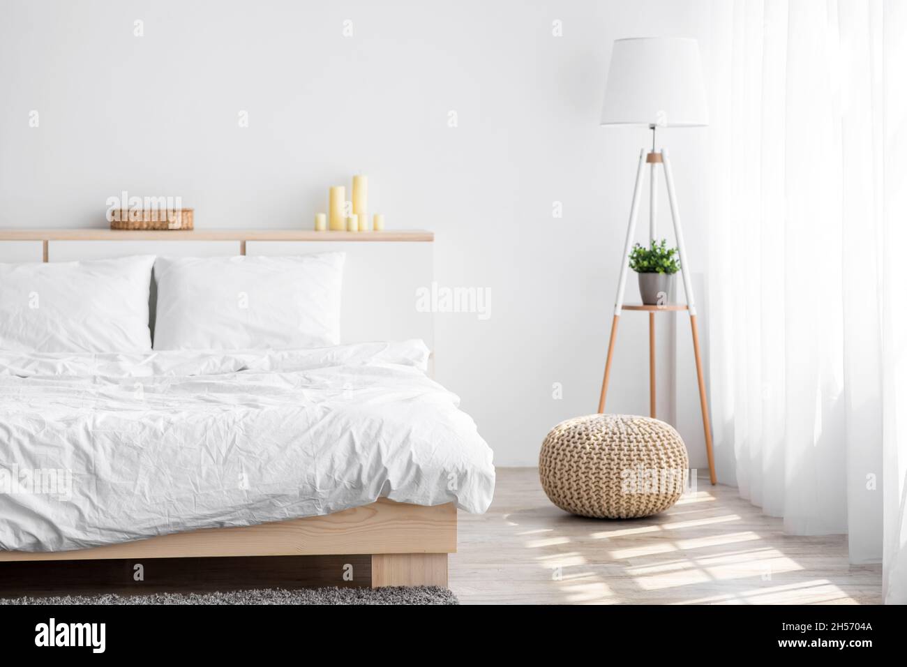 Soffice letto matrimoniale, lampada con pianta, mobili con accessori, finestra con tende su sfondo bianco Foto Stock