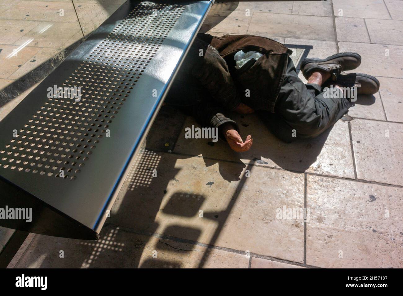 Perpignan, Francia, Street Scenes, senzatetto che dorme sul marciapiede vicino alla stazione ferroviaria, sotto la panchina pubblica della stazione degli autobus, povertà pubblica, vergogna delle città Foto Stock