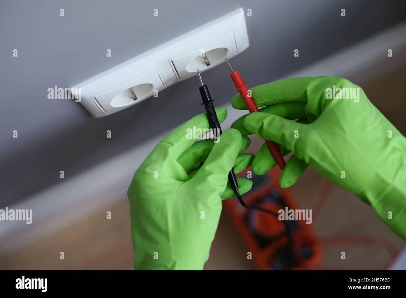 I guanti con le mani misurano la tensione nella presa con un attrezzo Foto Stock