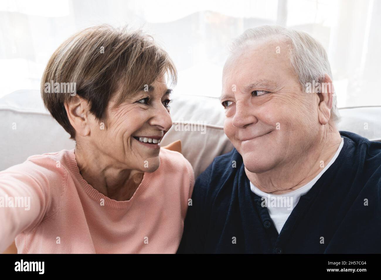 Coppia anziana felice che prende un selfie con il telefono cellulare a casa - persone anziane che utilizzano le tendenze tecnologiche Foto Stock