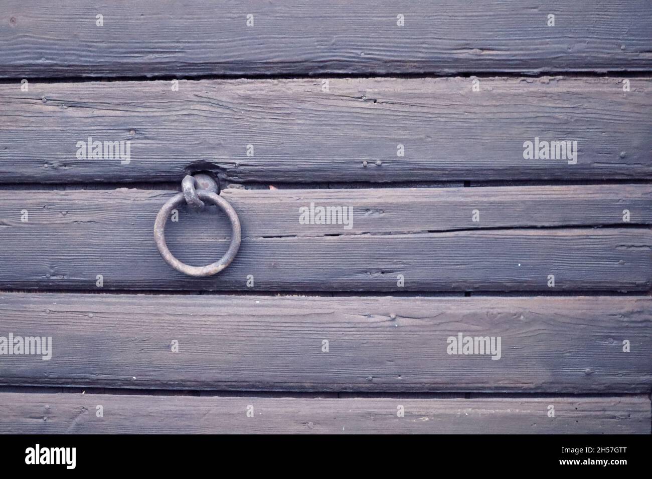 parete in legno con anello metallico e copyspace Foto Stock