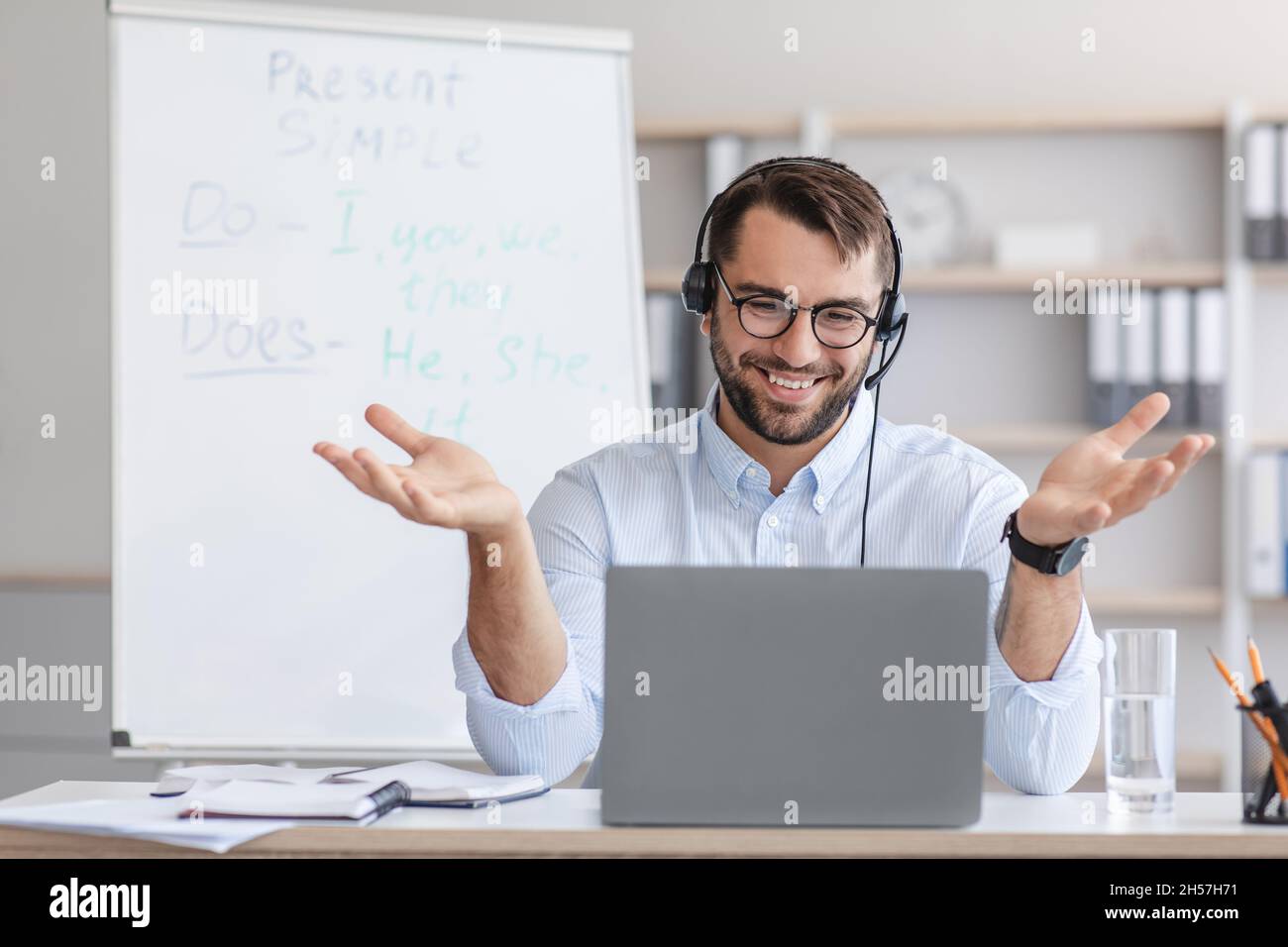 Allegro medio vecchio bell'insegnante di sesso maschile europeo in gesti occhiali, guarda la webcam portatile in ufficio domestico Foto Stock