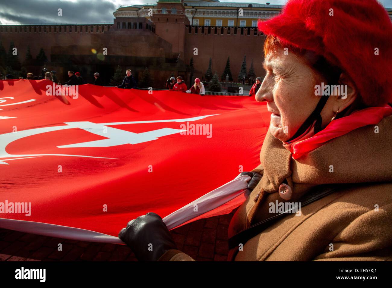 Mosca, Russia. Il 7 novembre 2021 sostenitori del partito comunista detengono un'enorme bandiera rossa mentre portano verso il Mausoleo del fondatore sovietico Vladimir Lenin sulla Piazza Rossa per celebrare il 104° anniversario della Rivoluzione del 1917 ottobre, a Mosca, in Russia Foto Stock