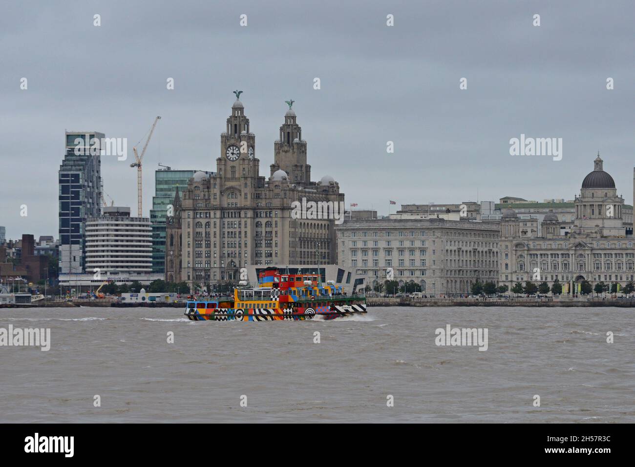 Il traghetto MV Snowdrop Mersey in livrea Razzle Dazzle visto passando il Royal Liver Building a Liverpool, Regno Unito Foto Stock