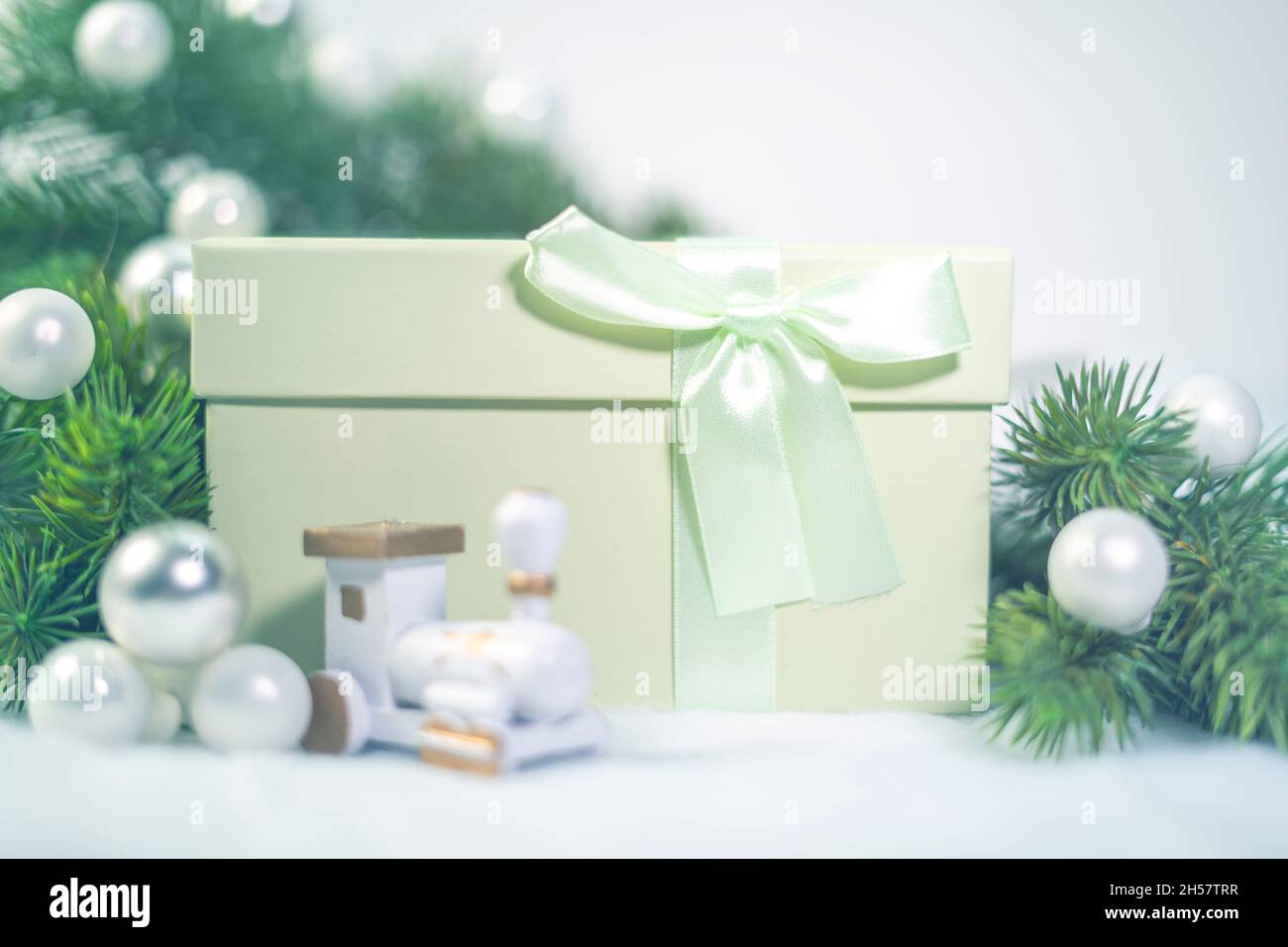 Confezione regalo verde a Natale. Ornamenti bianchi della sfera di Natale e rami di abete o pino. Foto Stock