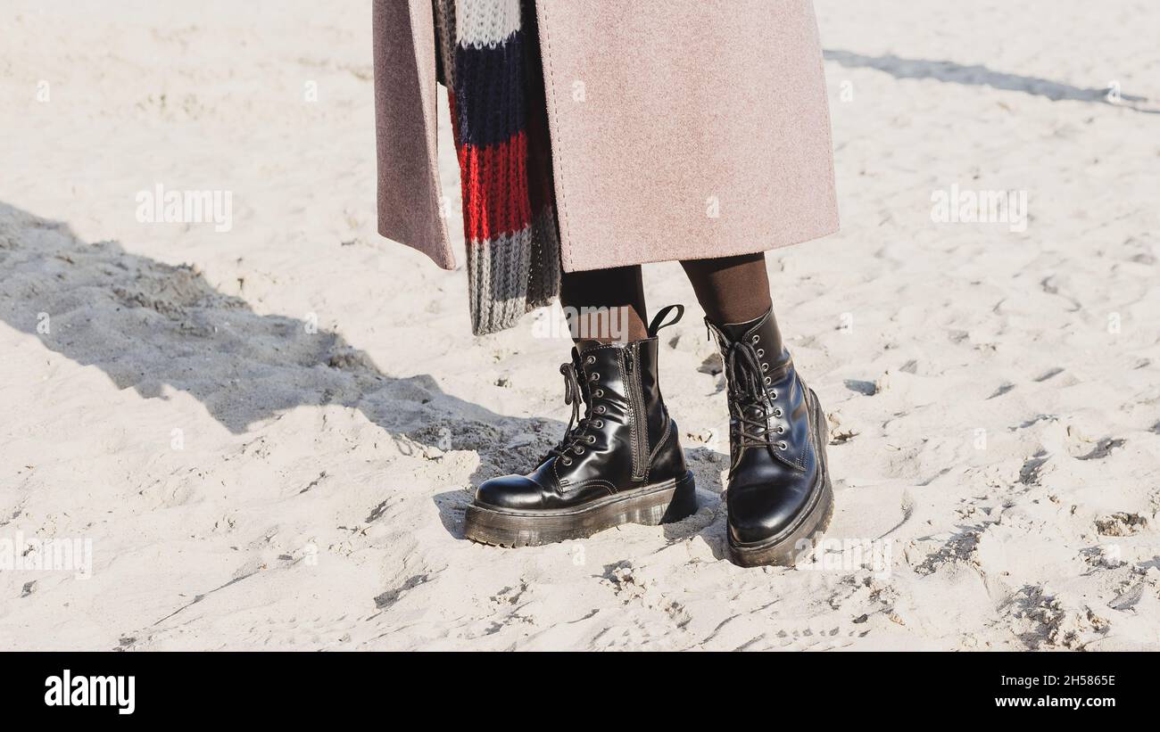 Eleganti stivaletti neri lisci in pelle all'aperto sulla spiaggia di  sabbia. Outfit stagione fredda Foto stock - Alamy