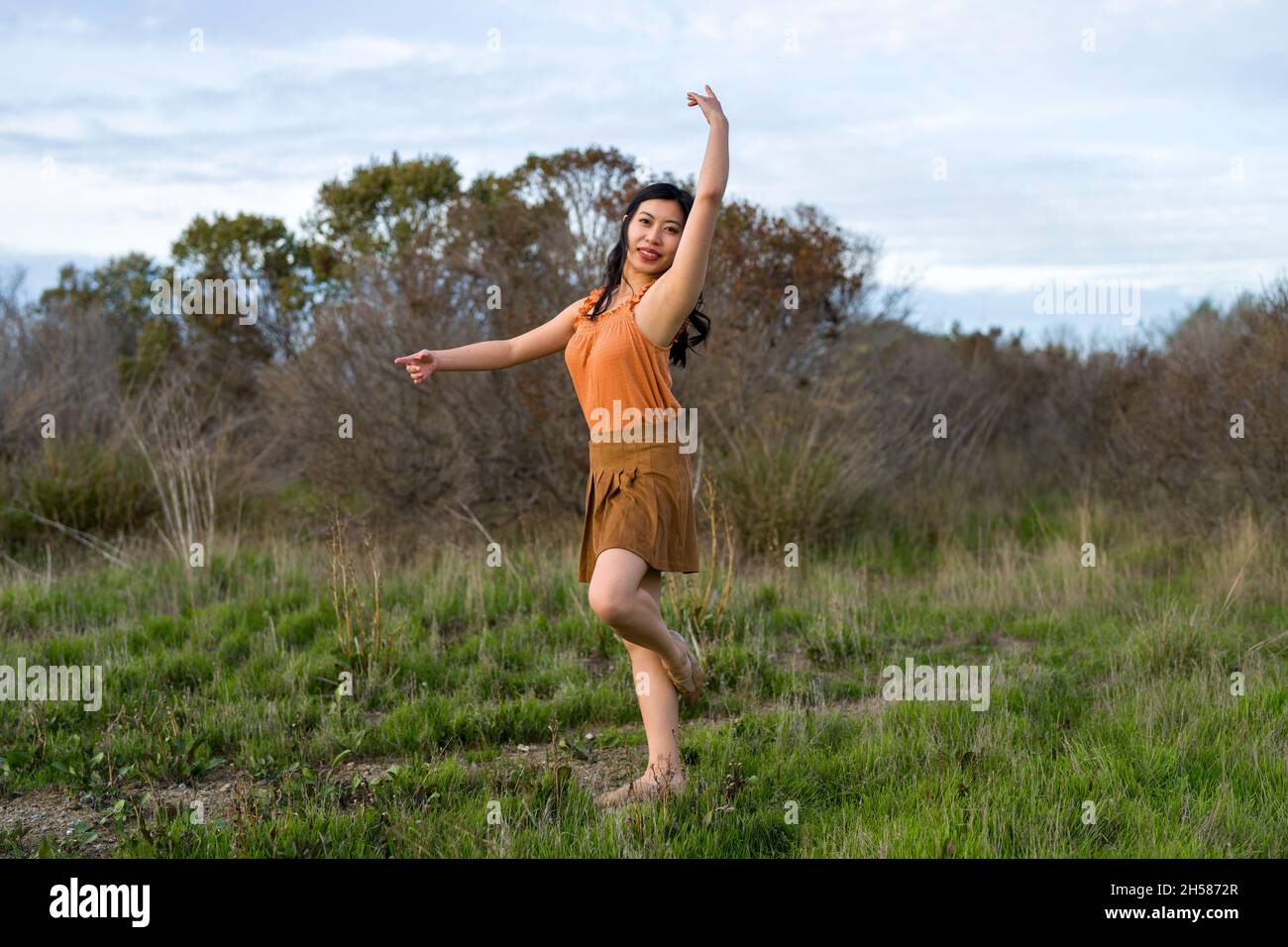 Donna in un vestito che fa il balletto si pone nelle Marshlands Foto Stock