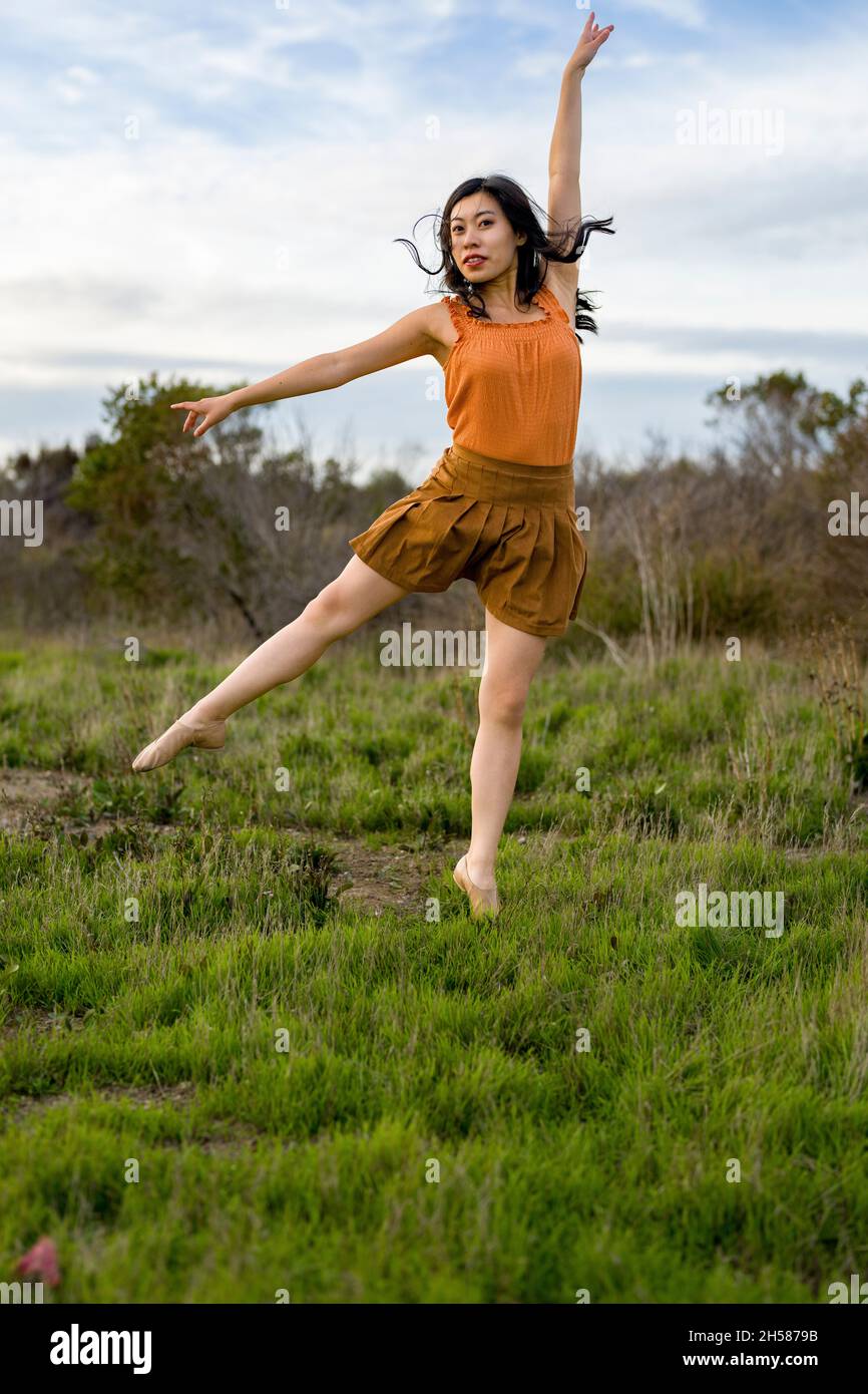 Donna in un vestito che fa il balletto si pone nelle Marshlands Foto Stock