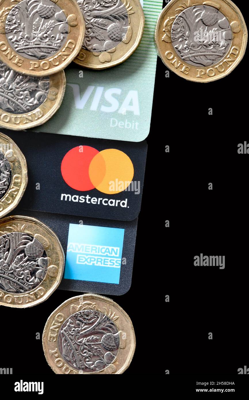Vista ravvicinata delle monete da 1 libbra sopra le carte anonime di credito e debito. Nessuna gente. Foto Stock
