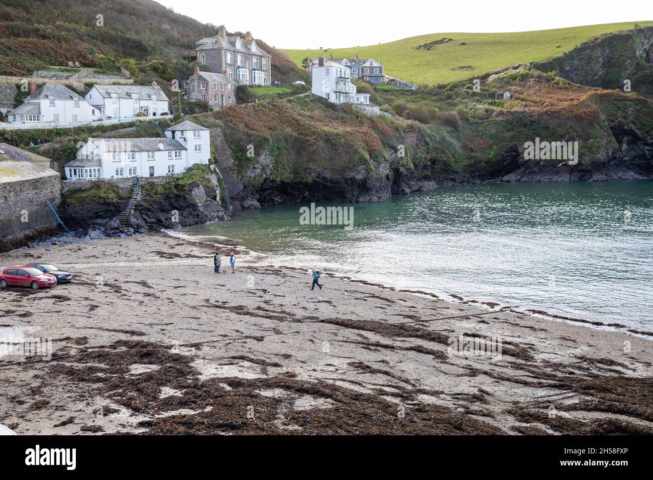 Auto e persone sulla spiaggia a Port Isaac, Cornovaglia resa famosa dalla serie TV Doc Martin Foto Stock