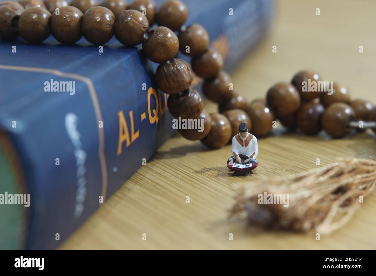 Simple Conceptual Photo, Islam Man or Muslim, Read al Quran, al Qur'an vicino al Real One e Wood Prayer Bead Foto Stock