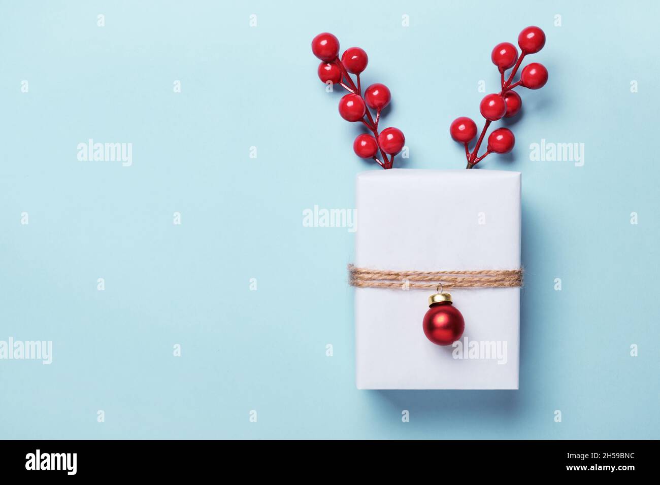 Scatola regalo di Natale confezionata in carta, decorata con bauble e spago. Idea di confezione regalo di Natale. Foto Stock