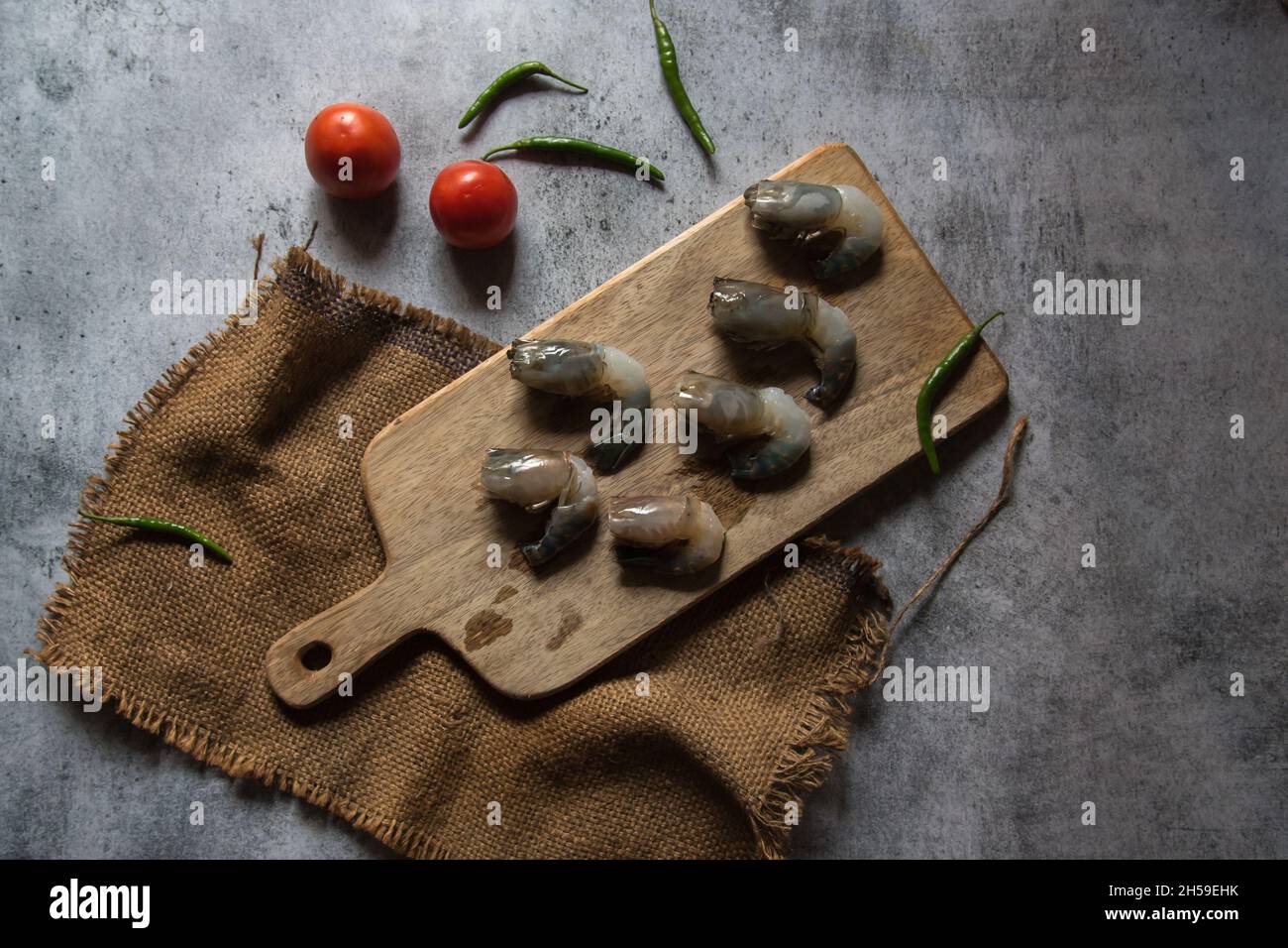 Gamberi crudi su un tagliere con uso di fuoco selettivo Foto Stock