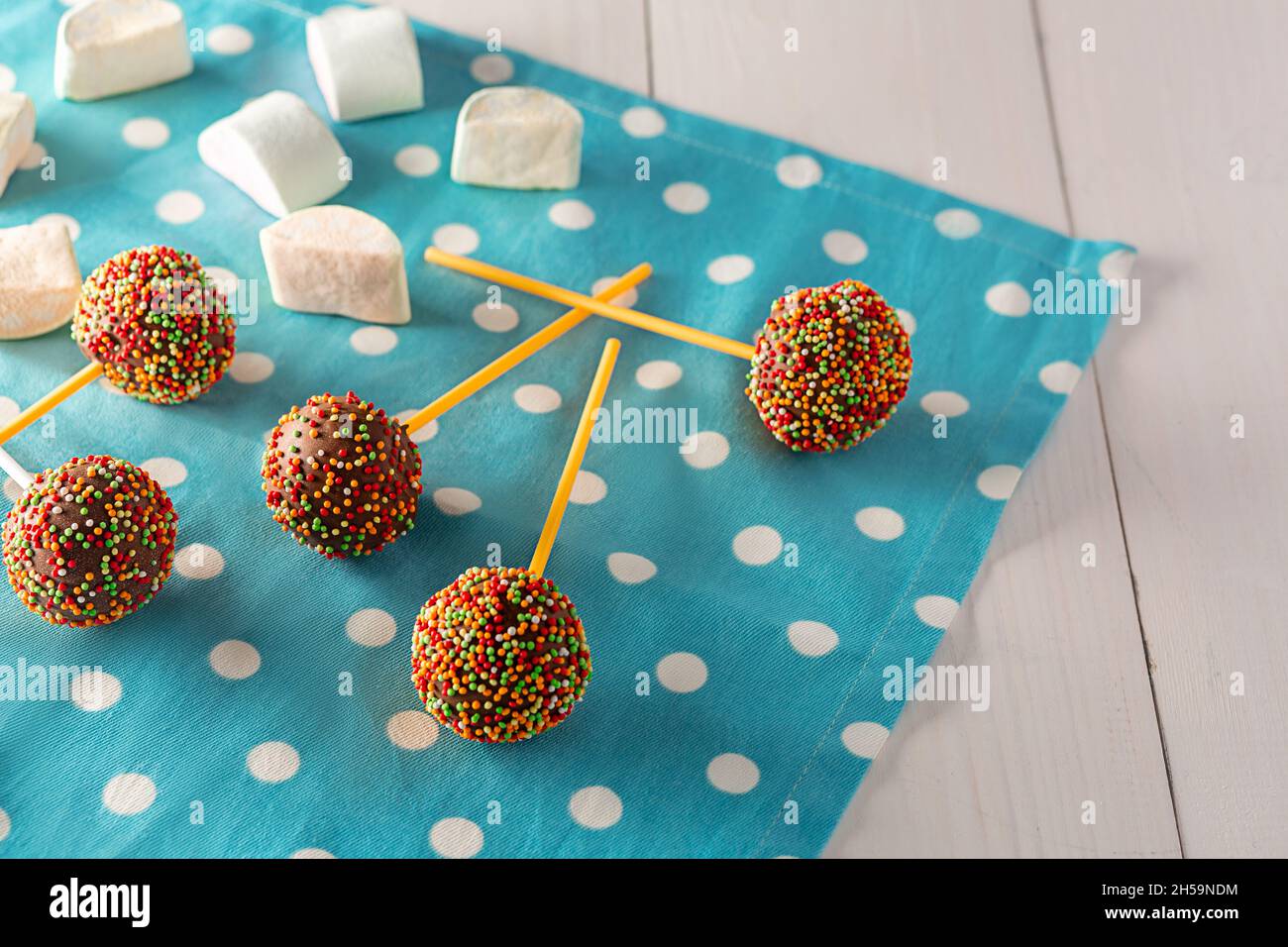 In casa piccola torte - cakepops per compleanno di bambini su un bianco sullo sfondo di legno. Foto Stock