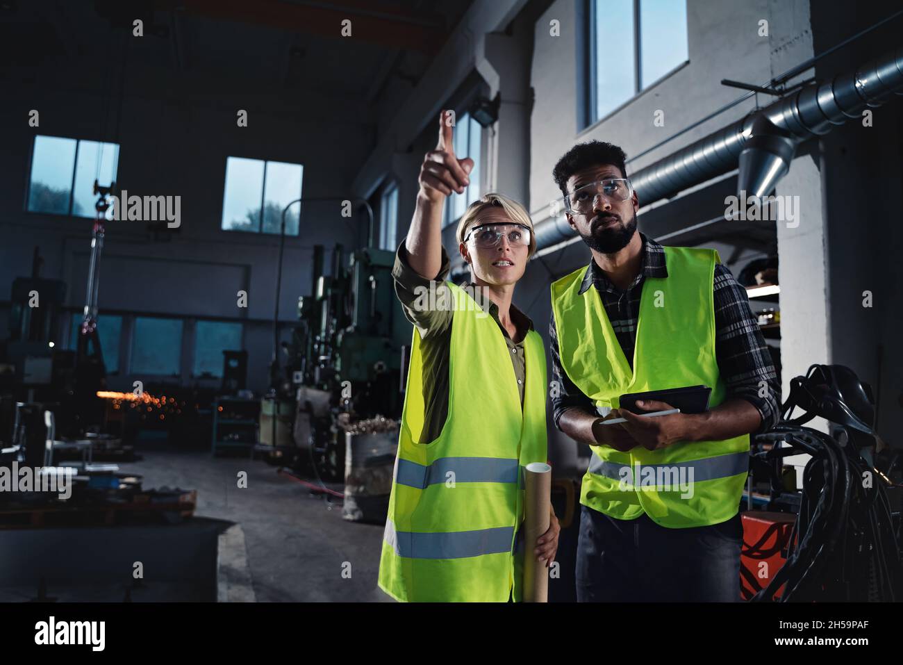 Ritratto di ispettori industriali che fanno un controllo generale in ambienti interni presso l'officina di metallo. Foto Stock