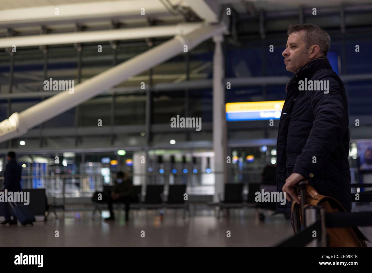 Un passeggero attende di effettuare il check-in sul volo American Airlines 101 tra Londra e New York a seguito della revoca delle restrizioni all'ingresso di cittadini non statunitensi imposte per contribuire a frenare la diffusione della coronavirus (COVID-19), all'aeroporto internazionale di Heathrow, a Londra, in Gran Bretagna, l'8 novembre 2021. REUTERS/Carlos Barria Foto Stock