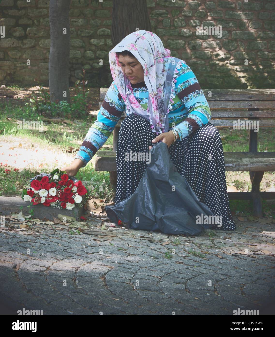 donna zingara venditore di fiori di strada a Istanbul che riposa in Gulhane Park, distretto di Eminonu, Turchia Foto Stock