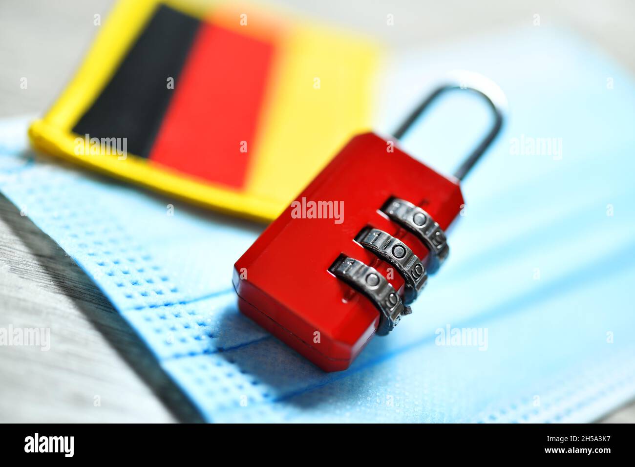 Rotes Nummernschloss auf Schutzmaske mit Deutschland-Fahne, Symbolfoto harter Lockdown Foto Stock