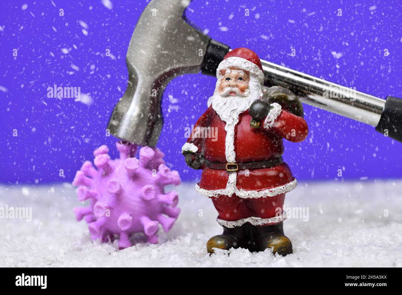 Weihnachtsmannfigur, Hammer und Coronavirus, Symbolfoto Corona-Weihnachten und Lockdown Foto Stock
