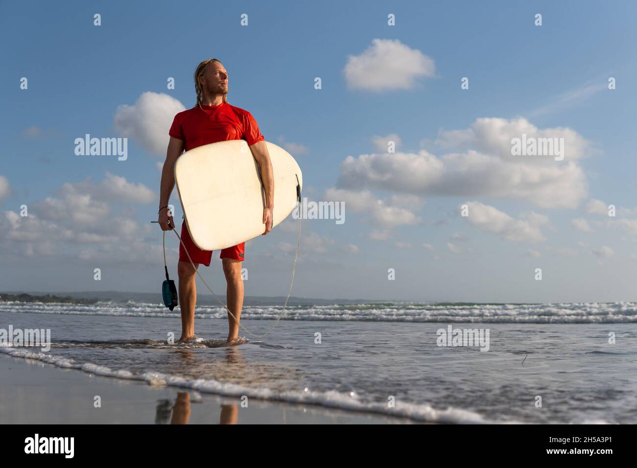 uomo surfer in ritratto rosso con tavola da surf. bali Foto Stock